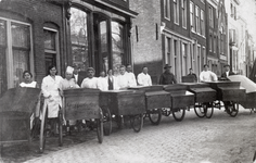 500272 Afbeelding van de bakkers en de broodbezorgers met hun broodkarren van bakkerij J. Moolenbeek (Nieuwegracht 125) ...
